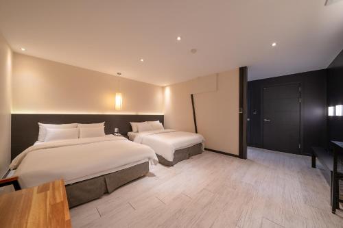 a hotel room with two beds and a table at Gong-Ju TouristHotel INK in Gongju
