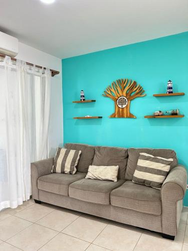 a couch in a living room with a blue wall at Villa Lapas in Bejuco