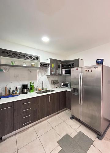 a large kitchen with a stainless steel refrigerator at Villa Lapas in Bejuco