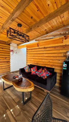 a living room with a black couch and a table at SENDERO REAL Mazamitla 3 in Mazamitla