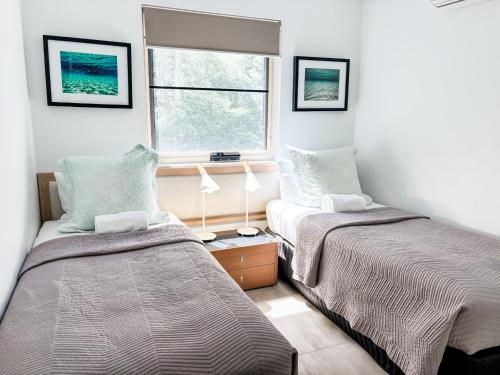 a bedroom with two beds and a window at Picture Point Terraces in Noosa Heads