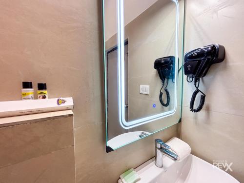 a bathroom with a mirror and a phone on the wall at The Neeraj River Forest Resort Ayurvedic Wellness Center in Rishīkesh