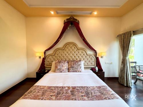 a bedroom with a large bed with a large headboard at The Neeraj River Forest Resort Ayurvedic Wellness Center in Rishīkesh
