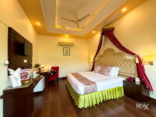 a hotel room with a bed and a television at The Neeraj River Forest Resort Ayurvedic Wellness Center in Rishīkesh