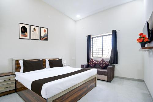 a bedroom with a large bed and a chair at Hotel O KVR snuggle in Bilāspur
