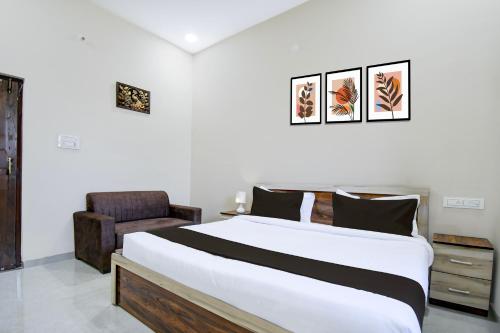 a bedroom with a large bed and a chair at Hotel O KVR snuggle in Bilāspur