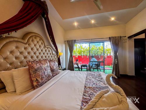 a bedroom with a large bed with a large window at The Neeraj River Forest Resort Ayurvedic Wellness Center in Rishīkesh