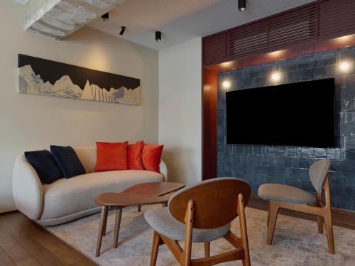 a living room with a couch and a tv at illi Tex Aoyama in Tokyo