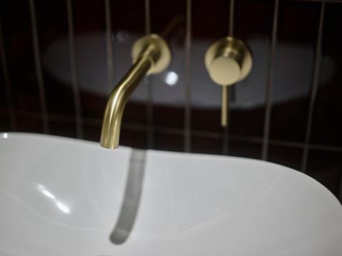 a gold hook on the side of a white table at illi Tex Aoyama in Tokyo
