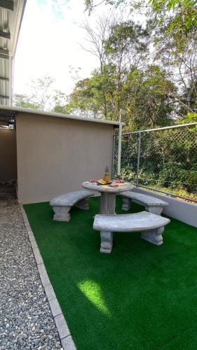 a picnic table on a patch of green grass at Casa Mi Puerto in Puerto Jiménez