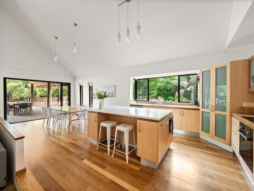 an open kitchen and living room with wood floors and windows at Caves Farm Guest House in Cowaramup