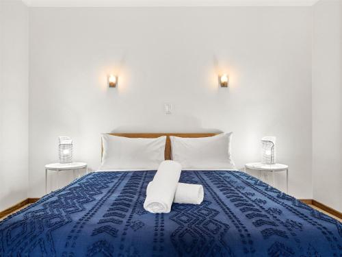 a blue bed with two white towels on it at Caves Farm Guest House in Cowaramup