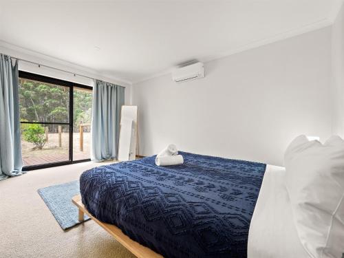 a bedroom with a bed and a large window at Caves Farm Guest House in Cowaramup