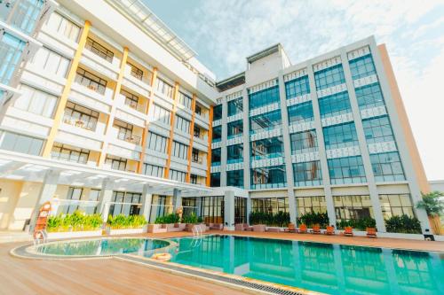 a hotel with a swimming pool in front of a building at De Balen Soultan Hotel in Puyung
