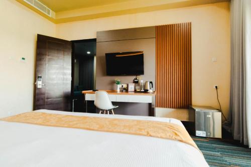 a hotel room with a bed and a desk at De Balen Soultan Hotel in Puyung