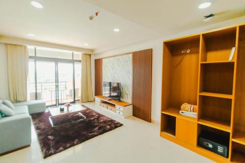 a living room with a couch and a television at De Balen Soultan Hotel in Puyung
