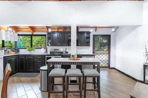 a kitchen with black cabinets and a table and chairs at Villa Sunrise - Incredible Ocean Views! in Ocotal