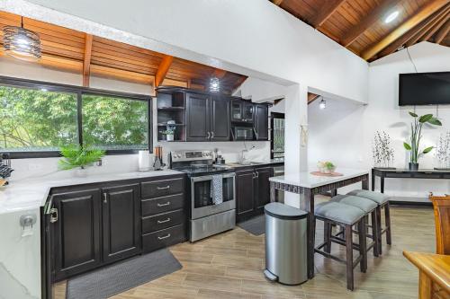 an open kitchen with black cabinets and a table at Villa Sunrise - Incredible Ocean Views! in Ocotal