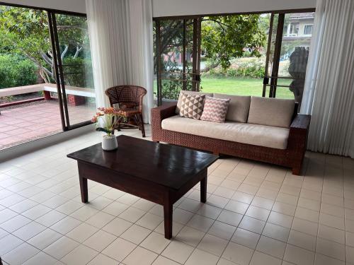 a living room with a couch and a coffee table at Baan Plumeria บ้านภูมิเรีย in Phetchaburi