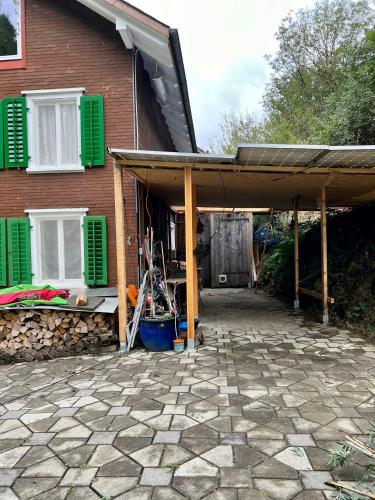 a house with a covered patio in front of it at Barn Apartment in an Old Farmhouse near Vaduz in Sevelen
