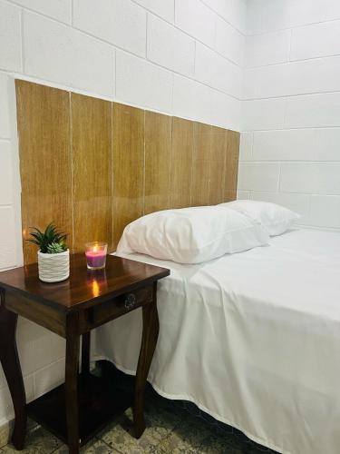 a bedroom with a table with a bed and a candle at Cowboys Home in Juayúa