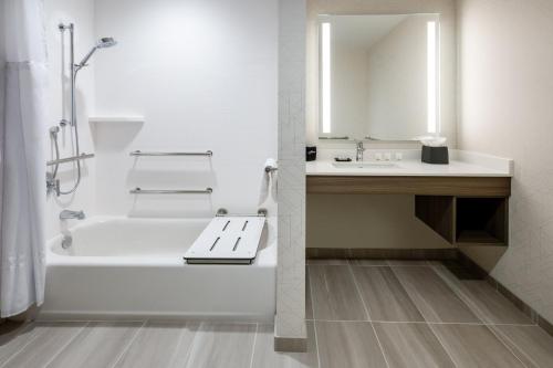a white bathroom with a tub and a sink at Holiday Inn Express & Suites Benson by IHG in Benson