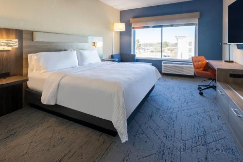 a hotel room with a large bed and a desk at Holiday Inn Express & Suites Benson by IHG in Benson