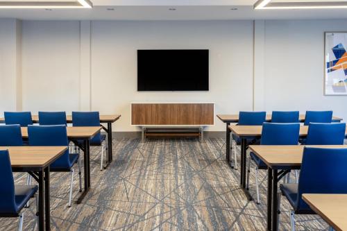 a classroom with tables and chairs and a tv at Holiday Inn Express & Suites Benson by IHG in Benson