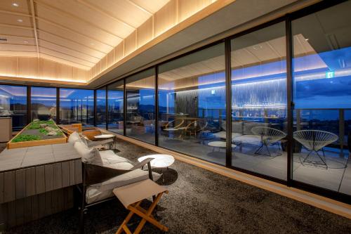 a living room with large windows and a view of the ocean at Kasyouen Bettei Fuka - Adult Only in Kyotango