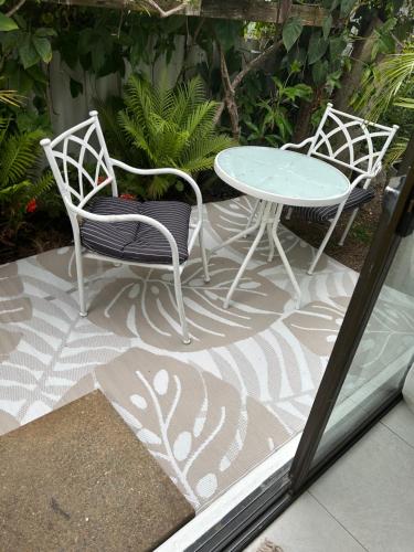 two chairs and a table on a patio at Garden Studio Tweed in Tweed Heads