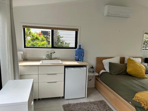 a small kitchen with a sink and a bed in a room at Garden Studio Tweed in Tweed Heads