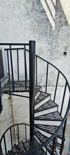 a metal spiral staircase with a pole in a building at Shree Krishna Guest House in Rīngas