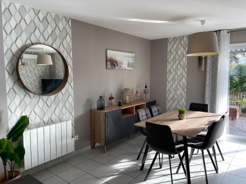 une salle à manger avec une table et un miroir dans l'établissement La maison de CASTETS entre forêt et océan, à Castets