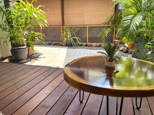 a wooden table sitting on a wooden deck with plants at Lodge Tahiti in Punaauia