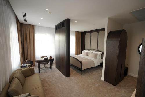 a hotel room with a bed and a couch at Kainar Hotel in Shymkent