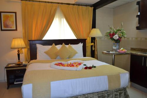 a bedroom with a bed with a tray of fruit on it at Al Hayat Hotel Apartments in Sharjah