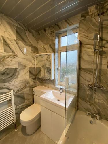 Lovely house for family & group في Wyken: حمام مع حوض ومرحاض وحوض استحمام