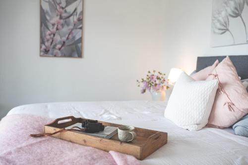 a tray with a camera and a cup on a bed at kentonviewsestate in Gumeracha