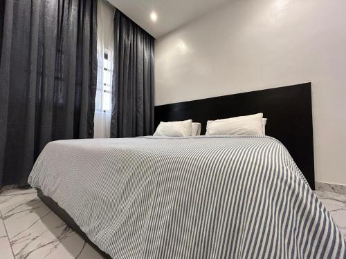 a bedroom with a large bed with a black and white blanket at OREMA Residence in Cotonou