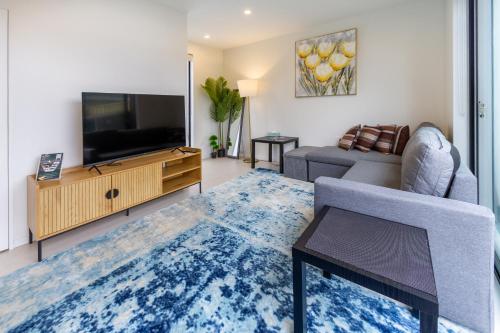 a living room with a television and a couch at Affordable Comfort 2BR with Carpark in Christchurch
