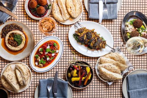 a table topped with plates of food and bowls of food at Ovolo The Valley Brisbane in Brisbane