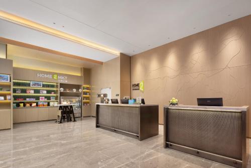 a lobby of a store with two reception desks at Home2 Suite by Hilton Kunming Xishan in Kunming