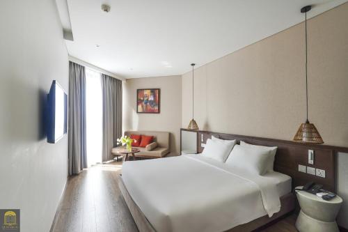 a bedroom with a large white bed and a couch at Mandala Pearl Azure Retreat in Ấp Nhơn Long