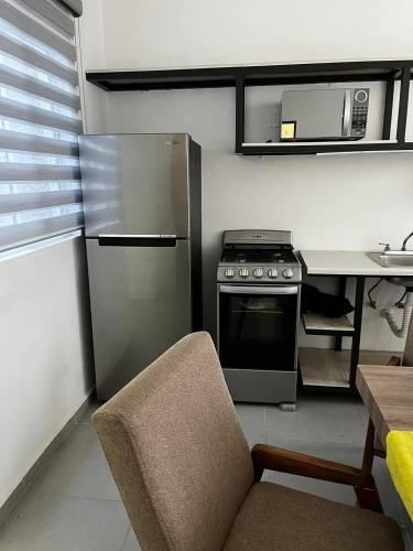 a kitchen with a stainless steel refrigerator and a table at Departamento San Cristóbal in Mexico City