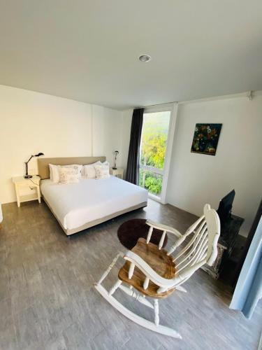 a bedroom with a white bed and a chair at Villa S in Hua Hin