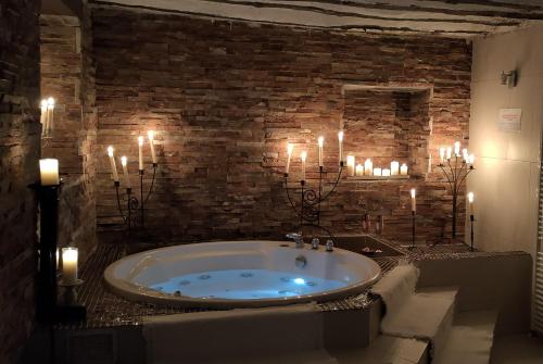 a bathroom with a bath tub with candles in it at Hotel La Casa del Canónigo in Caracenilla