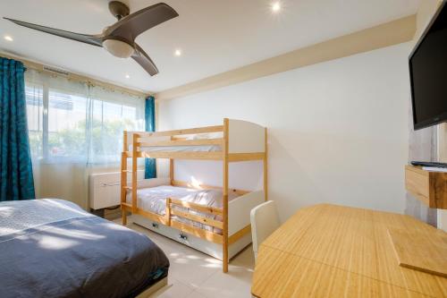 une chambre avec un lit superposé et une table dans l'établissement Appartement - Marina baie des Anges, à Villeneuve-Loubet