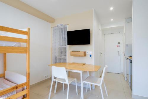 - une salle à manger avec une table, des chaises et des lits superposés dans l'établissement Appartement - Marina baie des Anges, à Villeneuve-Loubet