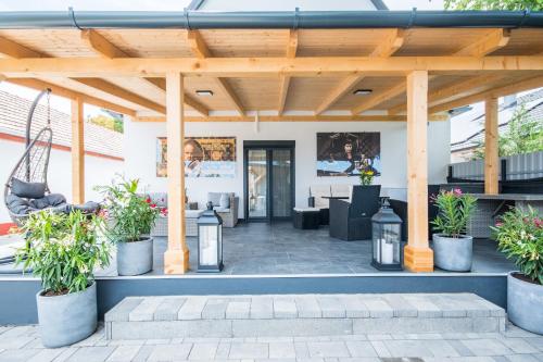 a patio with a wooden pergola with potted plants at Sunrise Palace in Sarud