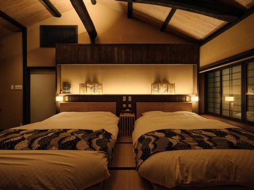 a room with two beds in a room at Tsumugi Nishinotoinhanayacho in Kyoto
